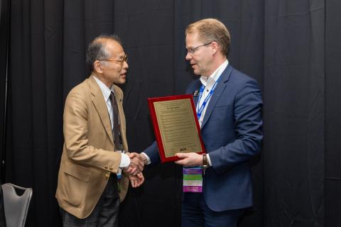 Dr. Koji Sugioka being presented Arthur L. Schawlow Plaque by Dr. Henrikki Pantsar.