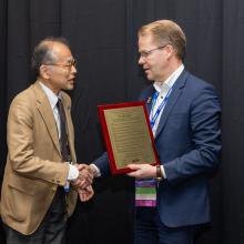 Dr. Koji Sugioka being presented Arthur L. Schawlow Plaque by Dr. Henrikki Pantsar.